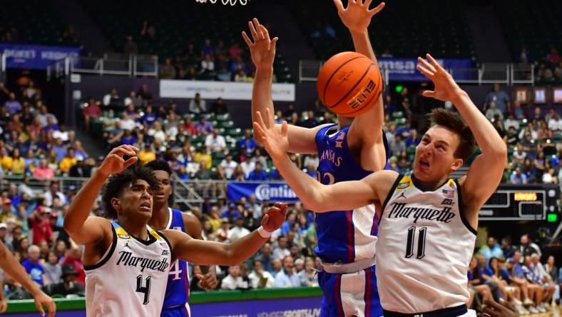 Nov 21, 2023; Honolulu, HI, USA; Kansas Jayhawks forward Parker Braun (23) fought for a rebound with Marquette Golden Eagles guard Stevie Mitchell (4) and guard Tyler Kolek (11) during the first period at SimpliFi Arena at Stan Sheriff Center. Mandatory Credit: Steven Erler-USA TODAY Sports