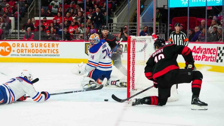 Nov 22, 2023; Raleigh, North Carolina, USA; Carolina Hurricanes center Jack Drury (18) scores a goal past Edmonton Oilers goaltender Stuart Skinner (74) during the first period at PNC Arena. Mandatory Credit: James Guillory-USA TODAY Sports