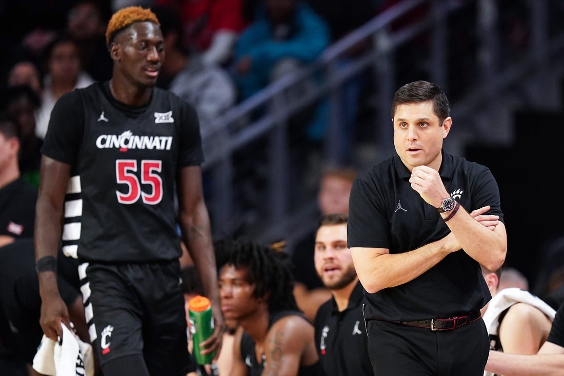 Cincinnati Bearcats head coach Wes Miller paces the sideline as Cincinnati Bearcats forward Aziz Bandaogo (55) finds a seat on the bench in the first half during an NCAA college basketball game between Georgia Tech Yellow Jackets and the Cincinnati Bearcats, Wednesday, Nov. 22, 2023, at Fifth Third Arena in Cincinnati.