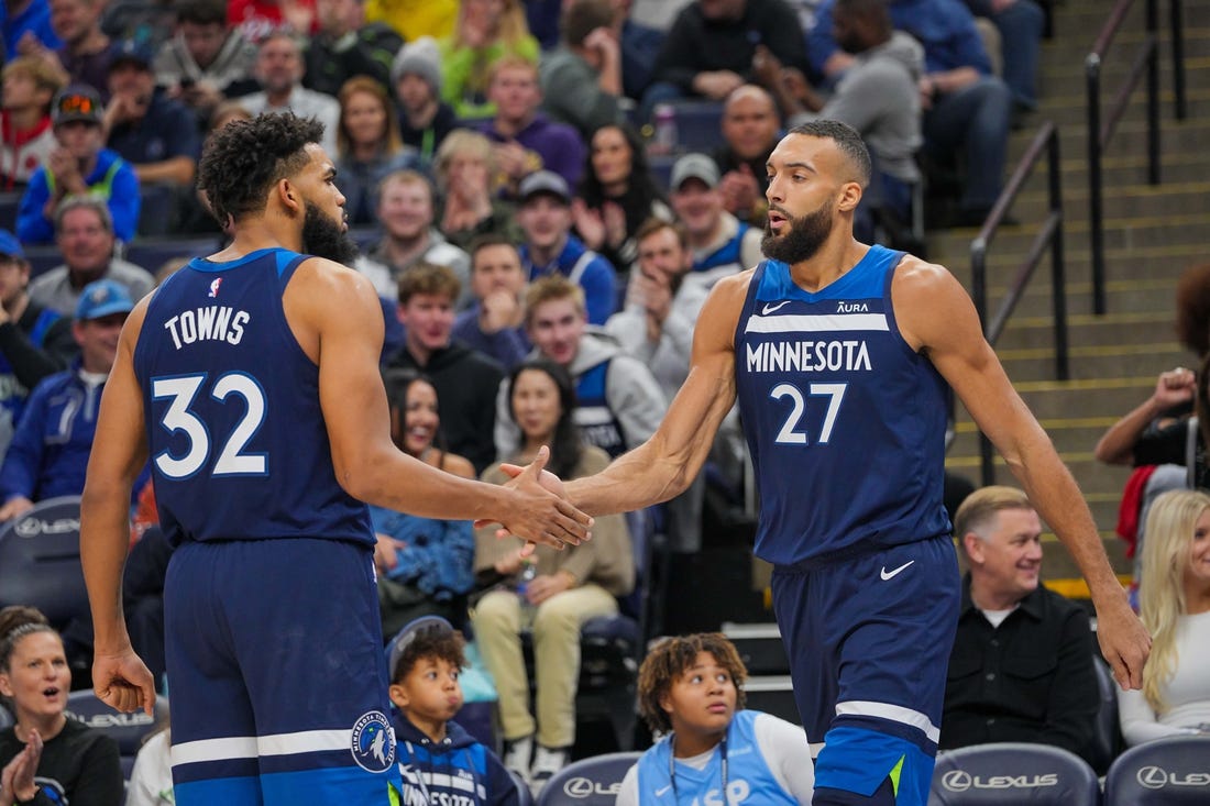 Nov 22, 2023; Minneapolis, Minnesota, USA; Minnesota Timberwolves center Karl-Anthony Towns (32) congratulates center Rudy Gobert (27) against the Philadelphia 76ers in the third quarter at Target Center. Mandatory Credit: Brad Rempel-USA TODAY Sports