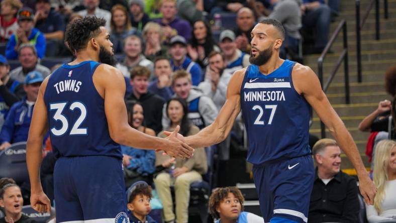 Nov 22, 2023; Minneapolis, Minnesota, USA; Minnesota Timberwolves center Karl-Anthony Towns (32) congratulates center Rudy Gobert (27) against the Philadelphia 76ers in the third quarter at Target Center. Mandatory Credit: Brad Rempel-USA TODAY Sports