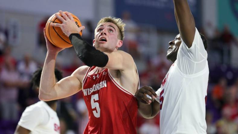 Nov 22, 2023; Fort Myers, FL, USA;  Wisconsin Badgers forward Tyler Wahl (5) drives tot the basket past Southern Methodist Mustangs forward Ja'Heim Hudson (15) in the second half during the Fort Myers Tip-Off championship game at Suncoast Credit Union Arena. Mandatory Credit: Nathan Ray Seebeck-USA TODAY Sports