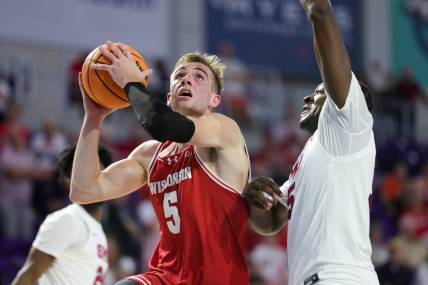 Nov 22, 2023; Fort Myers, FL, USA;  Wisconsin Badgers forward Tyler Wahl (5) drives tot the basket past Southern Methodist Mustangs forward Ja'Heim Hudson (15) in the second half during the Fort Myers Tip-Off championship game at Suncoast Credit Union Arena. Mandatory Credit: Nathan Ray Seebeck-USA TODAY Sports