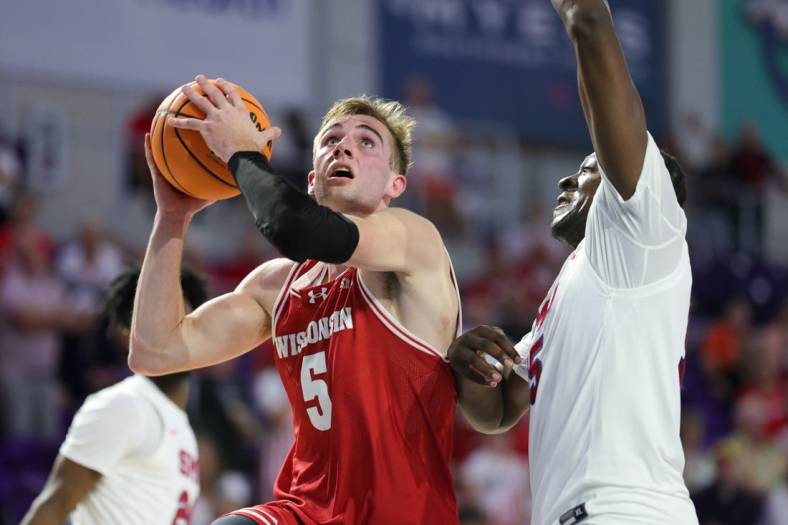 Nov 22, 2023; Fort Myers, FL, USA;  Wisconsin Badgers forward Tyler Wahl (5) drives tot the basket past Southern Methodist Mustangs forward Ja'Heim Hudson (15) in the second half during the Fort Myers Tip-Off championship game at Suncoast Credit Union Arena. Mandatory Credit: Nathan Ray Seebeck-USA TODAY Sports