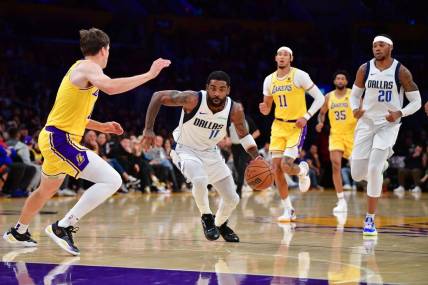 Nov 22, 2023; Los Angeles, California, USA; Dallas Mavericks guard Kyrie Irving (11) moves to the basket against Los Angeles Lakers guard Austin Reaves (15) during the first half at Crypto.com Arena. Mandatory Credit: Gary A. Vasquez-USA TODAY Sports