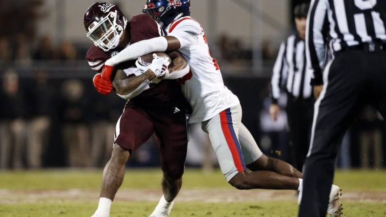 Nov 23, 2023; Starkville, Mississippi, USA; Mississippi State Bulldogs running back Jeffery Pittman (25) runs the ball as Mississippi Rebels linebacker Khari Coleman (23) makes the tackle during the first half at Davis Wade Stadium at Scott Field. Mandatory Credit: Petre Thomas-USA TODAY Sports