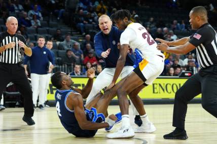 Nov 23, 2023; Las Vegas, Nevada, USA; Brigham Young Cougars head coach Mark Pope attempts to break up an altercation between Brigham Young Cougars forward Atiki Ally Atiki (4) and Arizona State Sun Devils forward Akil Watson (23) during the second half at Michelob Ultra Arena. Mandatory Credit: Stephen R. Sylvanie-USA TODAY Sports