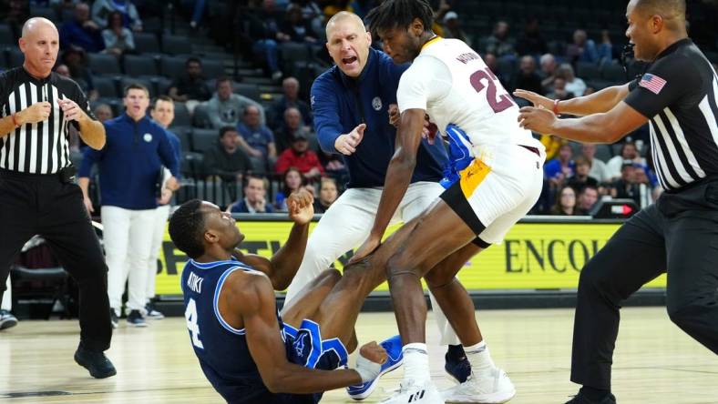 Nov 23, 2023; Las Vegas, Nevada, USA; Brigham Young Cougars head coach Mark Pope attempts to break up an altercation between Brigham Young Cougars forward Atiki Ally Atiki (4) and Arizona State Sun Devils forward Akil Watson (23) during the second half at Michelob Ultra Arena. Mandatory Credit: Stephen R. Sylvanie-USA TODAY Sports