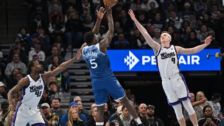 Nov 24, 2023; Minneapolis, Minnesota, USA; Sacramento Kings forward Harrison Barnes (40) and guard Kevin Huerter (9) defend the shot of Minnesota Timberwolves guard Anthony Edwards (5) during the first quarter at Target Center. Mandatory Credit: Jeffrey Becker-USA TODAY Sports