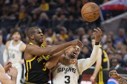 November 24, 2023; San Francisco, California, USA; Golden State Warriors guard Chris Paul (3, left) and San Antonio Spurs forward Keldon Johnson (3, right) fight for the rebound during the first quarter at Chase Center. Mandatory Credit: Kyle Terada-USA TODAY Sports