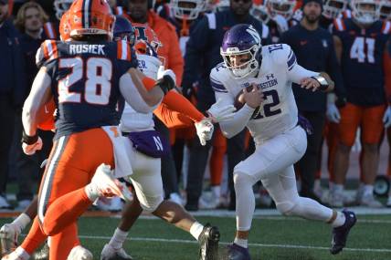 Nov 25, 2023; Champaign, Illinois, USA; Northwestern Wildcats quarterback Jack Lausch (12) rushes with the ball  during the first half against the Illinois Fighting Illini at Memorial Stadium. Mandatory Credit: Ron Johnson-USA TODAY Sports