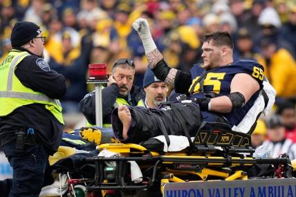 Nov 25, 2023; Ann Arbor, Michigan, USA; Michigan Wolverines offensive lineman Zak Zinter (65) is carted off by medics after an injury during the second half of the NCAA football game against the Michigan Wolverines at Michigan Stadium. Ohio State lost 30-24. Mandatory Credit: Adam Cairns-USA TODAY Sports