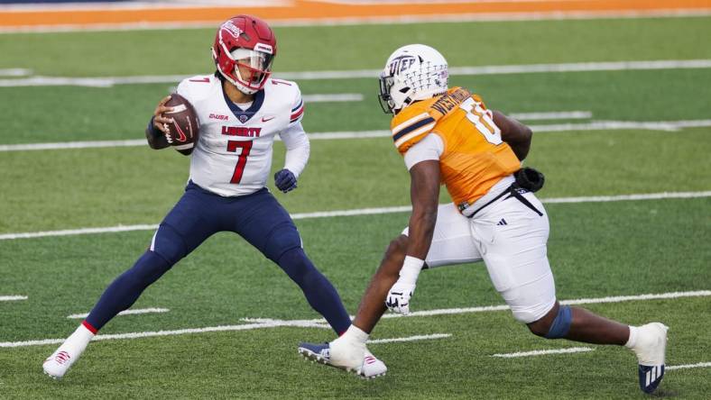 Nov 25, 2023; El Paso, Texas, USA; No. 22 Liberty Flames quarterback Kaidon Salter (7) tries to evade a UTEP Miners defensive end Maurice Westmoreland (0) during the first half at Sun Bowl Stadium. Mandatory Credit: Ivan Pierre Aguirre-USA TODAY Sports