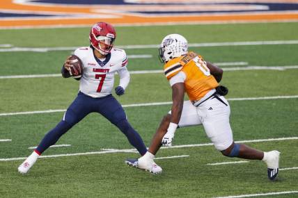 Nov 25, 2023; El Paso, Texas, USA; No. 22 Liberty Flames quarterback Kaidon Salter (7) tries to evade a UTEP Miners defensive end Maurice Westmoreland (0) during the first half at Sun Bowl Stadium. Mandatory Credit: Ivan Pierre Aguirre-USA TODAY Sports