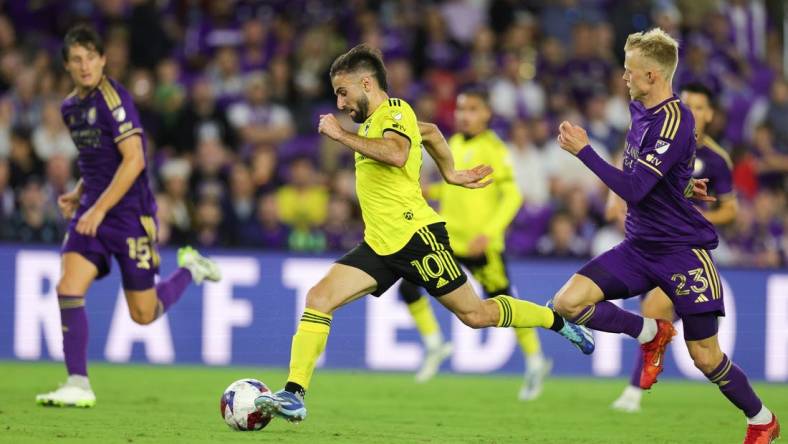 Nov 25, 2023; Orlando, Florida, USA; Columbus Crew forward Diego Rossi (10) dribbles the ball as Orlando City midfielder Dagur Dan Thorhallsson (23) defends during the second half in a MLS Cup Eastern Conference Semifinal match at Exploria Stadium. Mandatory Credit: Nathan Ray Seebeck-USA TODAY Sports