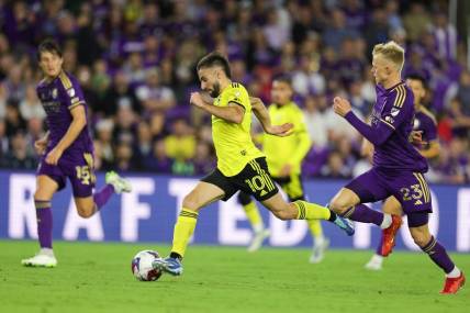 Nov 25, 2023; Orlando, Florida, USA; Columbus Crew forward Diego Rossi (10) dribbles the ball as Orlando City midfielder Dagur Dan Thorhallsson (23) defends during the second half in a MLS Cup Eastern Conference Semifinal match at Exploria Stadium. Mandatory Credit: Nathan Ray Seebeck-USA TODAY Sports