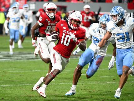 Nov 25, 2023; Raleigh, North Carolina, USA; North Carolina State Wolfpack receiver KC Concepcion (10) runs after a catch against North Carolina Tar Heels defensive back Will Hardy (31) during the first half at Carter-Finley Stadium. Mandatory Credit: Rob Kinnan-USA TODAY Sports