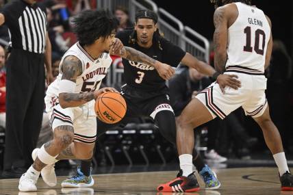 Nov 26, 2023; Louisville, Kentucky, USA; Louisville Cardinals guard Skyy Clark (55) dribbles against New Mexico State Aggies guard Christian Cook (3) during the first half at KFC Yum! Center. Mandatory Credit: Jamie Rhodes-USA TODAY Sports