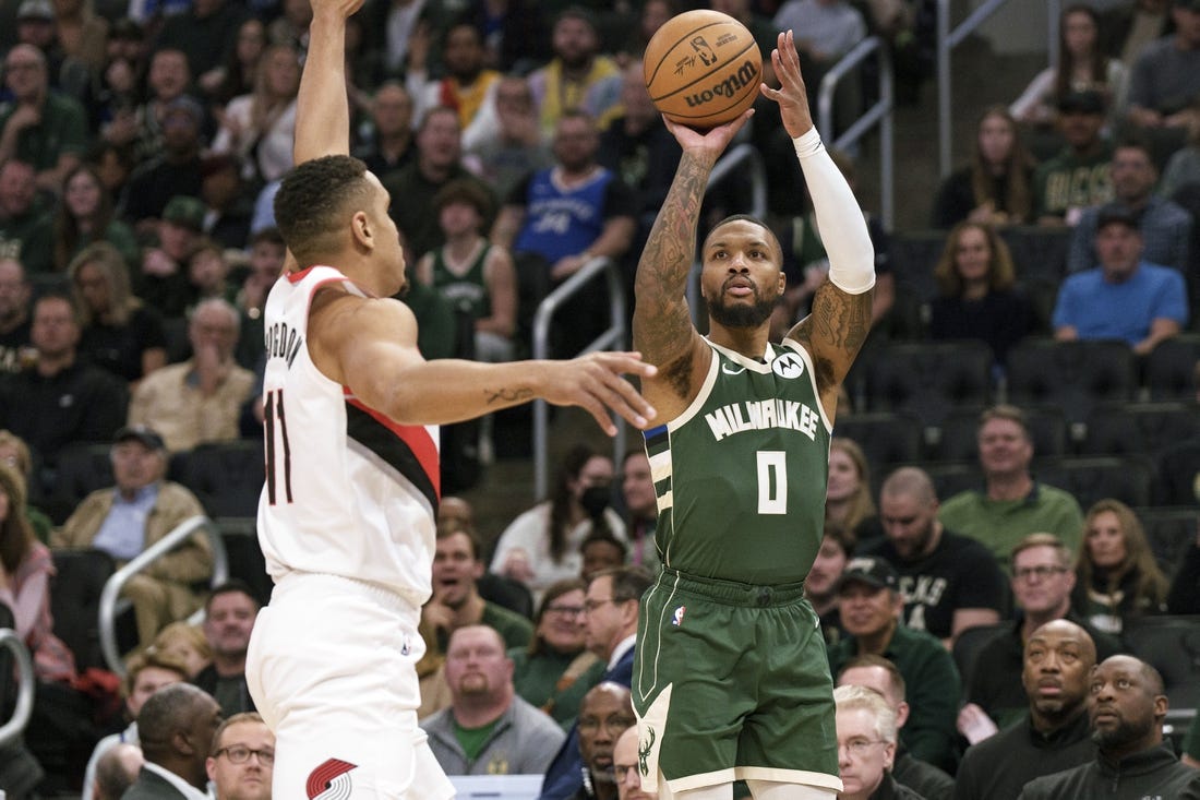 Nov 26, 2023; Milwaukee, Wisconsin, USA;  Milwaukee Bucks guard Damian Lillard (0) shoots against Portland Trail Blazers guard Malcolm Brogdon (11) during the first quarter at Fiserv Forum. Mandatory Credit: Jeff Hanisch-USA TODAY Sports