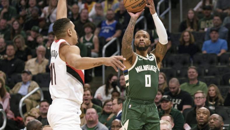 Nov 26, 2023; Milwaukee, Wisconsin, USA;  Milwaukee Bucks guard Damian Lillard (0) shoots against Portland Trail Blazers guard Malcolm Brogdon (11) during the first quarter at Fiserv Forum. Mandatory Credit: Jeff Hanisch-USA TODAY Sports