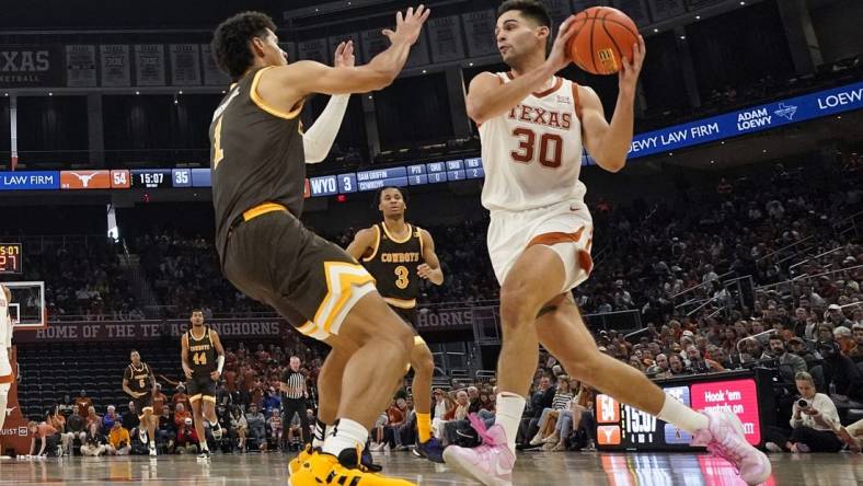 Nov 26, 2023; Austin, Texas, USA; Texas Longhorns forward Brock Cunningham (30) drives to the basket while defended by Wyoming Cowboys guard Brendan Wenzel (1) during the second half at Moody Center. Mandatory Credit: Scott Wachter-USA TODAY Sports