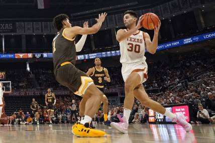 Nov 26, 2023; Austin, Texas, USA; Texas Longhorns forward Brock Cunningham (30) drives to the basket while defended by Wyoming Cowboys guard Brendan Wenzel (1) during the second half at Moody Center. Mandatory Credit: Scott Wachter-USA TODAY Sports
