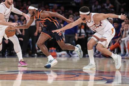 Nov 26, 2023; New York, New York, USA; New York Knicks guard Immanuel Quickley (5) steals the ball from Phoenix Suns guard Devin Booker (1) in the fourth quarter at Madison Square Garden. Mandatory Credit: Wendell Cruz-USA TODAY Sports