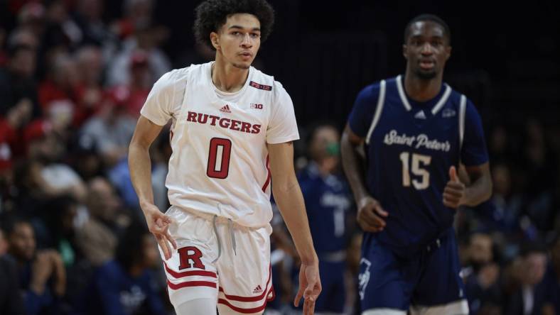 Nov 27, 2023; Piscataway, New Jersey, USA;  Rutgers Scarlet Knights guard Derek Simpson (0) reacts after making a three point basket in front of St. Peter's Peacocks forward Stephon Roberts (15) during the first half at Jersey Mike's Arena. Mandatory Credit: Vincent Carchietta-USA TODAY Sports