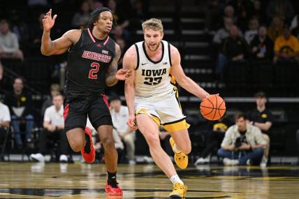 Nov 17, 2023; Iowa City, Iowa, USA; Iowa Hawkeyes forward Ben Krikke (23) controls the ball as Arkansas State Red Wolves guard Freddy Hicks (2) defends during the first half at Carver-Hawkeye Arena. Mandatory Credit: Jeffrey Becker-USA TODAY Sports