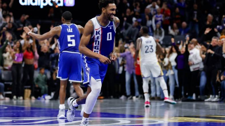 Nov 28, 2023; Sacramento, California, USA; Sacramento Kings guard Malik Monk (0) smiles after scoring a basket during the fourth quarter against the Golden State Warriors at Golden 1 Center. Mandatory Credit: Sergio Estrada-USA TODAY Sports