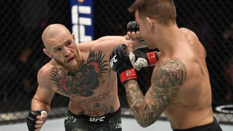 Jan 23, 2021; Abu Dhabi, United Arab Emirates; Conor McGregor of Ireland punches Dustin Poirier in a lightweight fight during the UFC 257 event inside Etihad Arena on UFC Fight Island.  Mandatory Credit: Jeff Bottari/Handout Photo via USA TODAY Sports