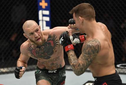 Jan 23, 2021; Abu Dhabi, United Arab Emirates; Conor McGregor of Ireland punches Dustin Poirier in a lightweight fight during the UFC 257 event inside Etihad Arena on UFC Fight Island.  Mandatory Credit: Jeff Bottari/Handout Photo via USA TODAY Sports