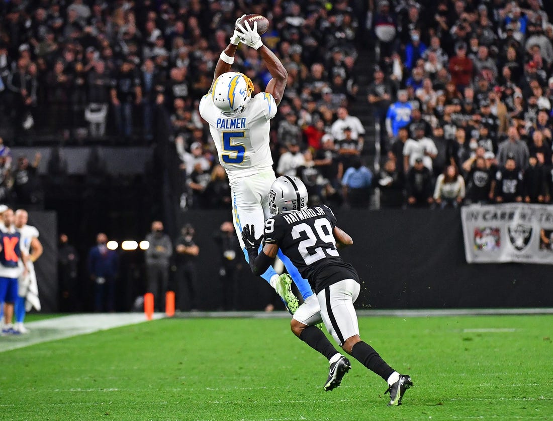 Jan 9, 2022; Paradise, Nevada, USA;Los Angeles Chargers wide receiver Josh Palmer (5) attempts catch a pass as Las Vegas Raiders cornerback Casey Hayward (29) defends during the fourth quarter at Allegiant Stadium. Mandatory Credit: Stephen R. Sylvanie-USA TODAY Sports