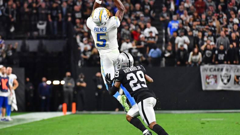 Jan 9, 2022; Paradise, Nevada, USA;Los Angeles Chargers wide receiver Josh Palmer (5) attempts catch a pass as Las Vegas Raiders cornerback Casey Hayward (29) defends during the fourth quarter at Allegiant Stadium. Mandatory Credit: Stephen R. Sylvanie-USA TODAY Sports