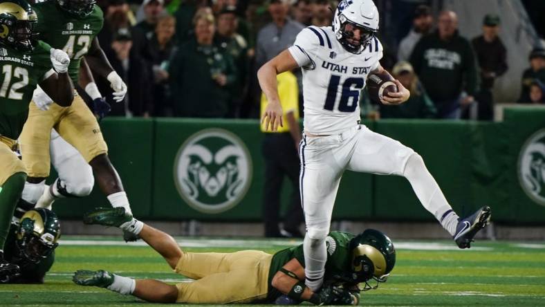 Oct 15, 2022; Fort Collins, Colorado, USA; Utah State Aggies quarterback Levi Williams (16) can't escape the grasp of a Colorado State Rams defender at Sonny Lubick Field at Canvas Stadium. Mandatory Credit: Michael Madrid-USA TODAY Sports