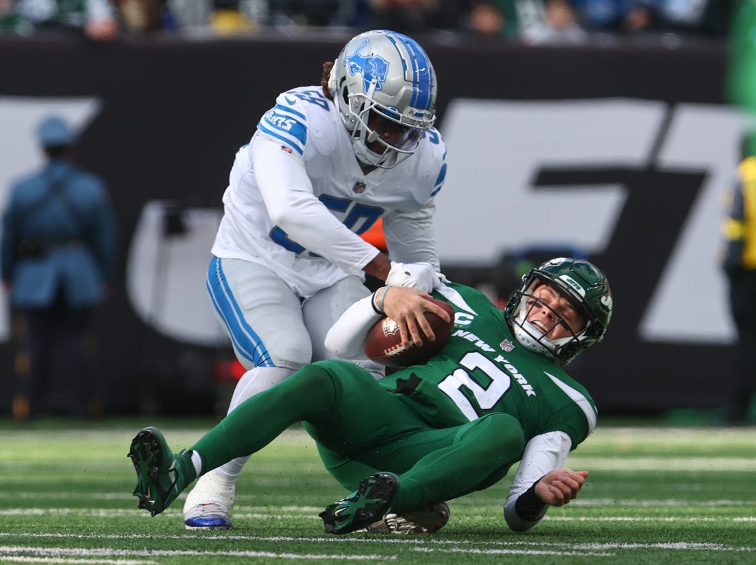 Dec 18, 2022; East Rutherford, New Jersey, USA; New York Jets quarterback Zach Wilson (2) is sacked by Detroit Lions linebacker James Houston (59) during the first half at MetLife Stadium. Mandatory Credit: Ed Mulholland-USA TODAY Sports