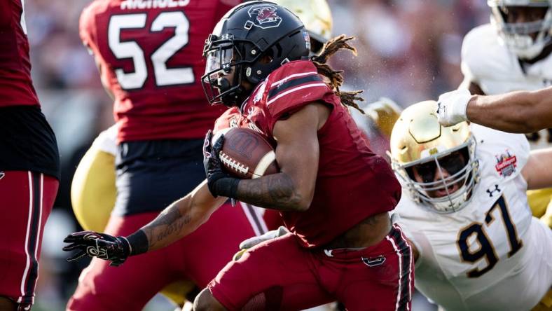 Dec 30, 2022; Jacksonville, FL, USA; South Carolina Gamecocks wide receiver Antwane Wells Jr. (3) runs with the ball away from Notre Dame Fighting Irish defensive lineman Gabriel Rubio (97) during the first half in the 2022 Gator Bowl at TIAA Bank Field. Mandatory Credit: Matt Pendleton-USA TODAY Sports