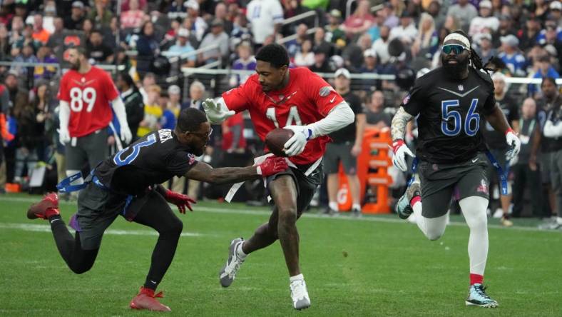 Feb 5, 2023; Paradise, Nevada, USA; AFC receiver Stefon Diggs of the Buffalo Bills (14) carries the ball against NFC strong safety Budda Baker of the Arizona Cardinals (3) and linebacker Demario Davis of the New Orleans Saints (56) during the Pro Bowl Games at Allegiant Stadium. Mandatory Credit: Kirby Lee-USA TODAY Sports