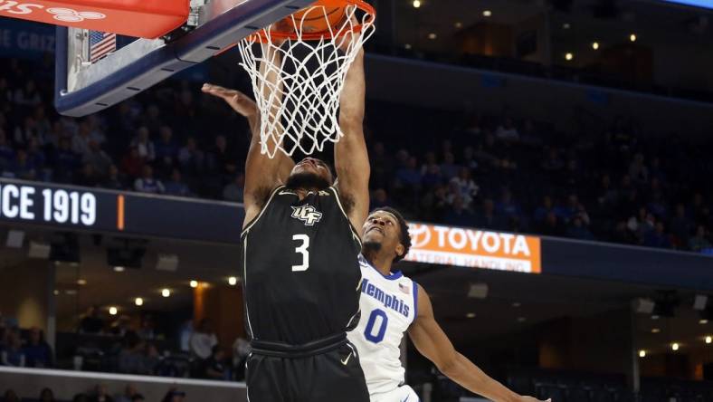 Feb 16, 2023; Memphis, Tennessee, USA; UCF Knights guard Darius Johnson (3) drives to the basket as Memphis Tigers guard Elijah McCadden (0) defends during the second half at FedExForum. Mandatory Credit: Petre Thomas-USA TODAY Sports