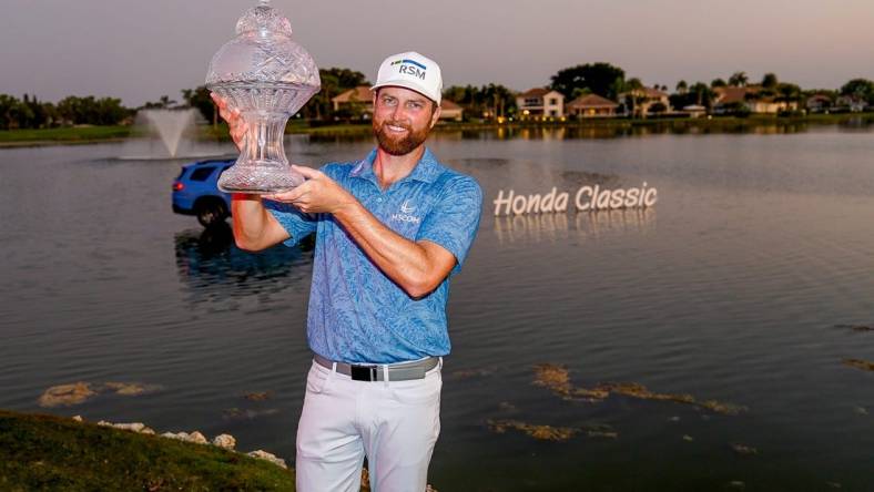 Chris Kirk holds the championship trophy after his playoff victory over Eric Cole in the final round of the Honda Classic at PGA National Resort & Spa on Sunday, February 26, 2023, in Palm Beach Gardens, FL.