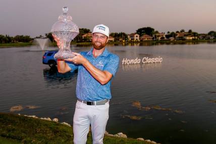 Chris Kirk holds the championship trophy after his playoff victory over Eric Cole in the final round of the Honda Classic at PGA National Resort & Spa on Sunday, February 26, 2023, in Palm Beach Gardens, FL.