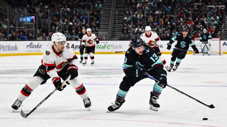 Mar 9, 2023; Seattle, Washington, USA; Seattle Kraken left wing Brandon Tanev (13) plays the puck while being defended by Ottawa Senators defenseman Artem Zub (2) during the third period at Climate Pledge Arena. Ottawa defeated Seattle 5-4. Mandatory Credit: Steven Bisig-USA TODAY Sports