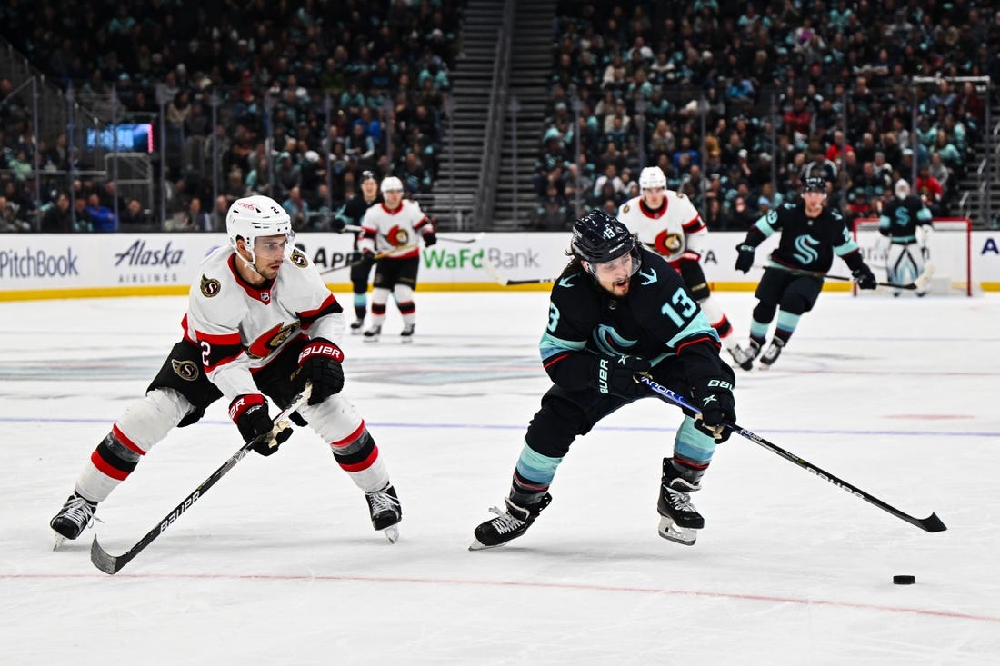 Mar 9, 2023; Seattle, Washington, USA; Seattle Kraken left wing Brandon Tanev (13) plays the puck while being defended by Ottawa Senators defenseman Artem Zub (2) during the third period at Climate Pledge Arena. Ottawa defeated Seattle 5-4. Mandatory Credit: Steven Bisig-USA TODAY Sports