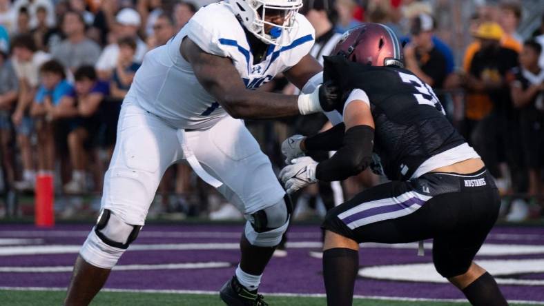 IMG's Jordan Seaton (77) holds off Lipscomb's Beck Woodside (35) at Lipscomb's Reese Smith Football Field in Nashville, Tenn., Friday night, Aug. 18, 2023.