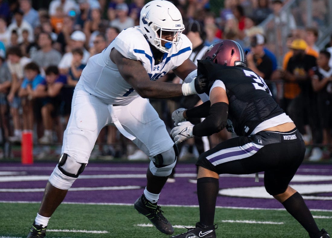 IMG's Jordan Seaton (77) holds off Lipscomb's Beck Woodside (35) at Lipscomb's Reese Smith Football Field in Nashville, Tenn., Friday night, Aug. 18, 2023.