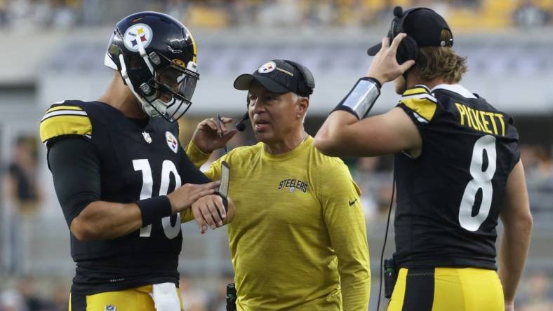 Aug 19, 2023; Pittsburgh, Pennsylvania, USA;  Pittsburgh Steelers quarterbacks Mitch Trubisky (10) and Kenny Pickett (8) talk with quarterbacks coach Mike Sullivan (middle) against the Buffalo Bills during the second quarter at Acrisure Stadium. Mandatory Credit: Charles LeClaire-USA TODAY Sports