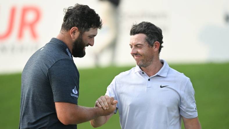 Aug 24, 2023; Atlanta, Georgia, USA; Jon Rahm shakes hands with Rory McIlroy on the 18th green during the first round of the TOUR Championship golf tournament at East Lake Golf Club. Mandatory Credit: Adam Hagy-USA TODAY Sports