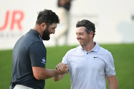 Aug 24, 2023; Atlanta, Georgia, USA; Jon Rahm shakes hands with Rory McIlroy on the 18th green during the first round of the TOUR Championship golf tournament at East Lake Golf Club. Mandatory Credit: Adam Hagy-USA TODAY Sports