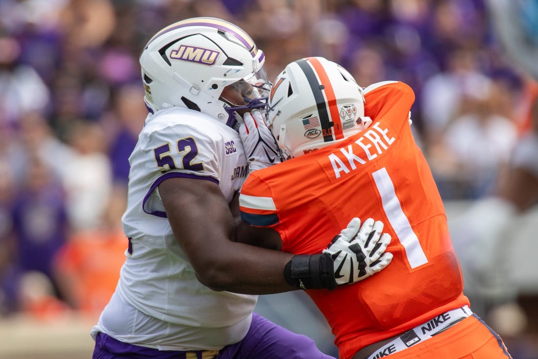 September 9, 22023 in Charlottesville, Virginia; James Madison Dukes offensive lineman Tyshawn Wyatt (52) blocks Virginia Cavaliers defensive end Paul Akere (1) during the first half of the game at Scott Stadium.  Mandatory Credit: Hannah Pajewski-USA TODAY Sports