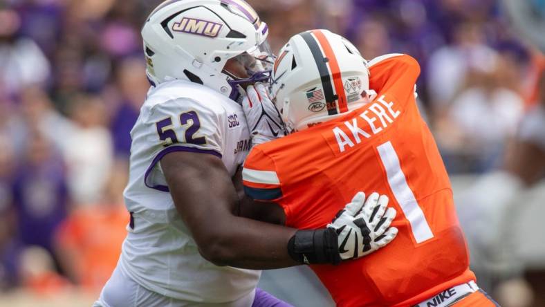 September 9, 22023 in Charlottesville, Virginia; James Madison Dukes offensive lineman Tyshawn Wyatt (52) blocks Virginia Cavaliers defensive end Paul Akere (1) during the first half of the game at Scott Stadium.  Mandatory Credit: Hannah Pajewski-USA TODAY Sports